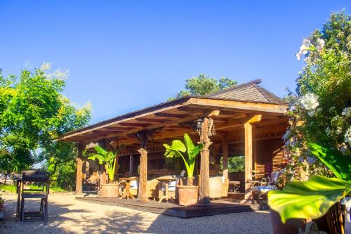 a wooden pavilion with a table and chairs in it at Villa Vanille in Boisseron
