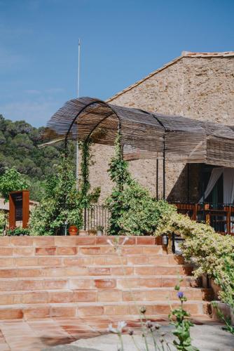 a brick building with stairs in front of it at ECOTurisme Can Buch HOTEL in Sant Aniol de Finestras