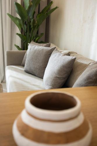a vase sitting on a table in front of a couch at Pnoes Luxury Suites in Paliouri