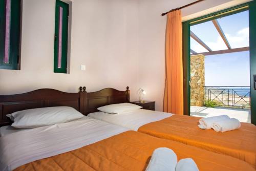 twee bedden in een slaapkamer met uitzicht op de oceaan bij Villa Κτήμα Νικόλα in Likórrevma