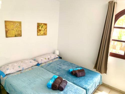 a bed with two pillows on it in a bedroom at Casa Delfin in Corralejo