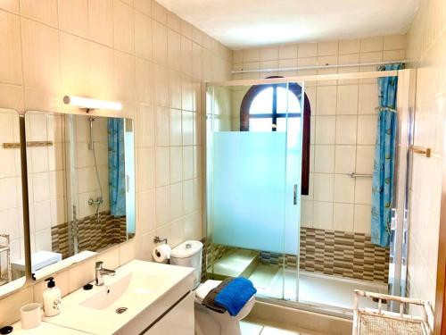 a bathroom with a sink and a glass shower at Casa Delfin in Corralejo