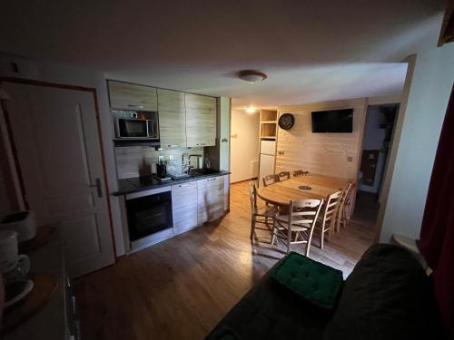 a kitchen and dining room with a table and chairs at Chamrousse Appart 8 personnes au pied des pistes in Chamrousse