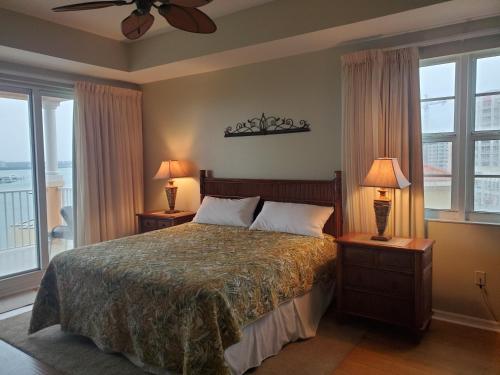 a bedroom with a bed with two lamps and windows at Luxury 5 Star Condominium Water Front 3 Beds 2 Bath Pool Hot-Tub Beach And City Views in Clearwater Beach