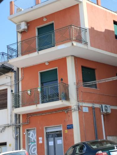 a red building with balconies on a street at AurHouse in Castel di Iudica