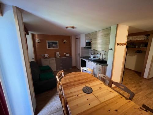 a wooden table in a room with a kitchen at Chamrousse Appart 8 personnes au pied des pistes in Chamrousse