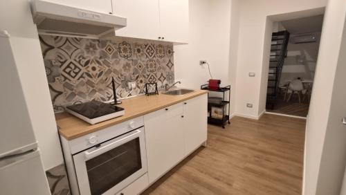 a kitchen with a sink and a stove top oven at MAISON VENTIMIGLIA 83 in Catania