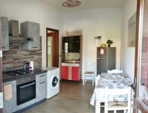 a kitchen with a table and a stove top oven at Casa Vacanze"Il Bouganville" in Carbonia