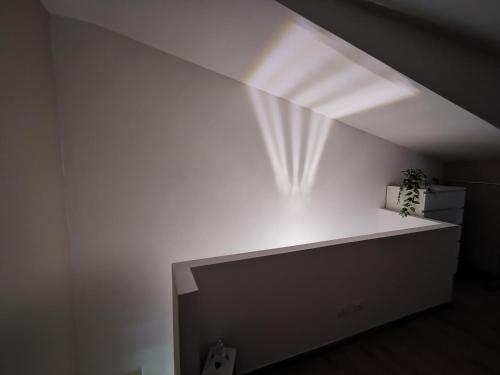 a room with a white wall and a white shelf at Via Subiaco Guest House in Marco Simone