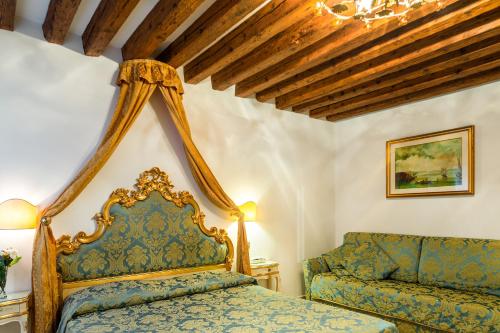 a bedroom with a bed and a couch at Hotel Al Vagon in Venice