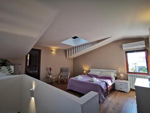 sypialnia z łóżkiem z fioletową narzutą w obiekcie Via Subiaco guest house w mieście Marco Simone
