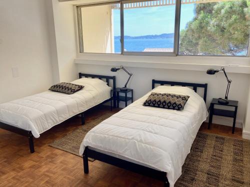deux lits dans une chambre avec une fenêtre dans l'établissement Grand Duplex climatisé avec terrasse face à la mer, à Sainte-Maxime