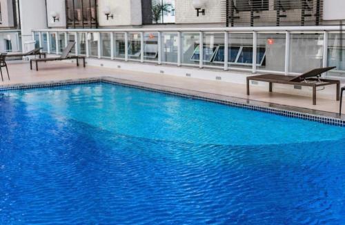 a large blue swimming pool in a building at Flat Aguas Claras 218 S4 in Brasilia