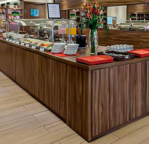 a restaurant counter with red napkins and dishes on it at Flat Aguas Claras 218 S4 in Brasilia