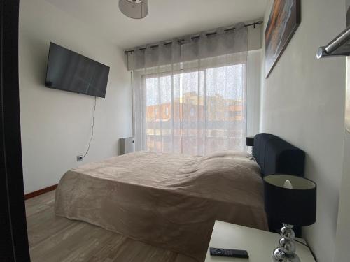 a bedroom with a bed and a window and a desk at Le Maxime 7 in Sainte-Maxime