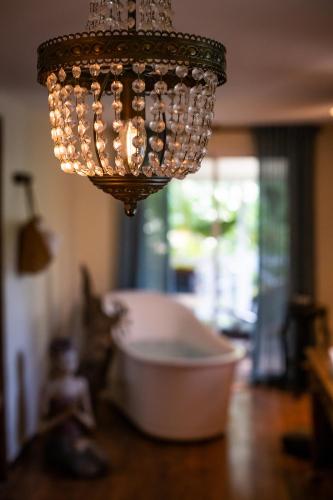 a chandelier hanging over a bath tub in a room at Villa Vanille in Boisseron
