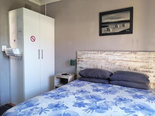 a bedroom with a bed with a blue comforter at The Private and Cosy Guest House 3 in Germiston