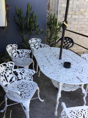 a white table with chairs and an umbrella at Trotamundo Oaxaca Hostel in Oaxaca City