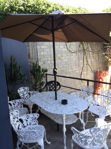 a table and chairs with an umbrella on a patio at Trotamundo Oaxaca Hostel in Oaxaca City