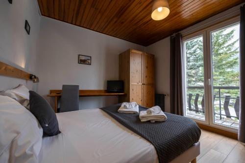 a bedroom with a bed with two towels on it at Hôtel les Flocons in Le Sauze