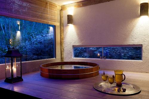 a room with a large window and a round tub at Capim do Mato Pousada & Spa by L'Occitane in Serra do Cipo