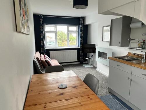 a kitchen with a wooden table and chairs in a room at Godrevy Lighthouse View, Carbis Bay, St Ives, free parking near beach in Carbis Bay