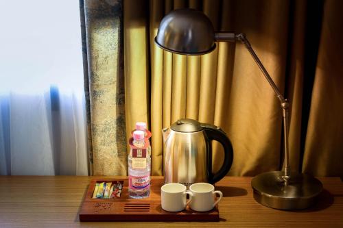 Una mesa con una cafetera y dos tazas. en SYM Hôtel, en Cheraga