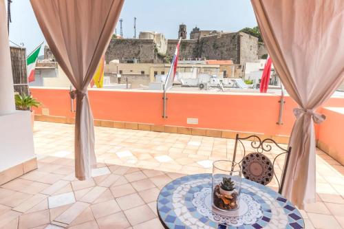 a table on a balcony with a view of a city at Residence Alberghiero Eolie in Lipari
