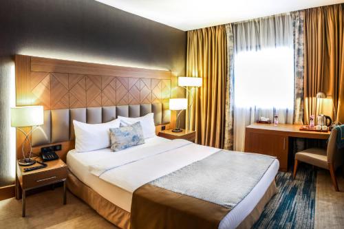 a hotel room with a bed and a desk at SYM Hôtel in Cheraga