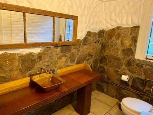 Baño de piedra con lavabo y aseo en Sobrado dos Polacos en Gramado