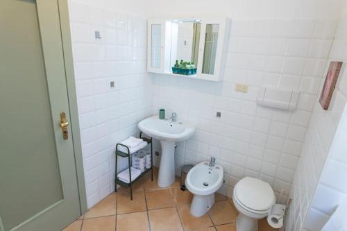 a white bathroom with a toilet and a sink at Vaccaj Home cultura musica e mare a Pesaro by Yohome in Pesaro