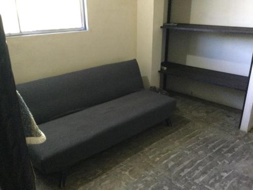 a couch sitting in the corner of a room at Trotamundo Oaxaca Hostel in Oaxaca City