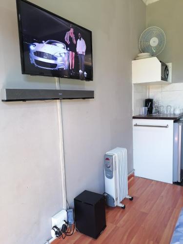 a flat screen tv hanging on a wall in a living room at The Private and Cosy Guest House 3 in Germiston