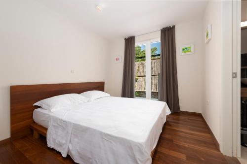 a bedroom with a white bed and a window at New Five Star Superior Apartment in Zaton