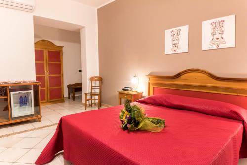 a bedroom with a red bed with a red blanket at Residence Alberghiero Eolie in Lipari