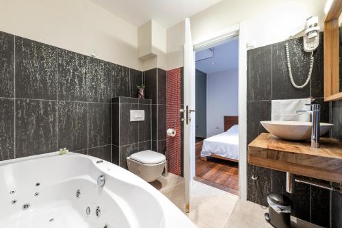 La salle de bains est pourvue d'une baignoire, de toilettes et d'un lavabo. dans l'établissement New Five Star Superior Apartment, à Zaton