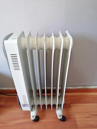 a white radiator sitting on the floor next to a wall at The Private and Cosy Guest House 3 in Germiston