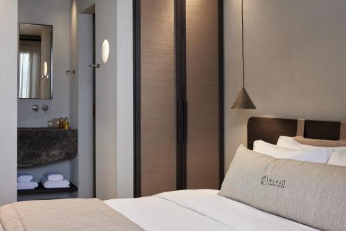a hotel room with a bed and a mirror at Alaso Design Suites in Fira