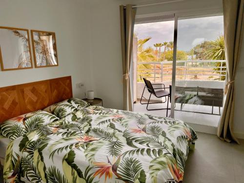 um quarto com uma cama e uma varanda com vista em Palm Beach Paradise - Private access to the beach em Villajoyosa