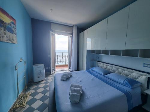 una camera blu con letto e vista sull'oceano di Tocco di mare a Porto Santo Stefano