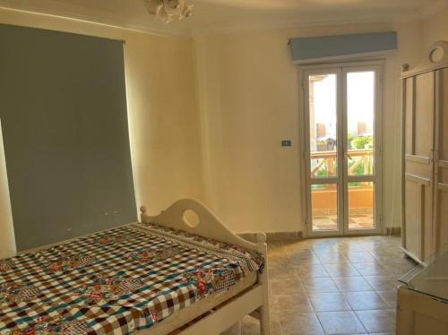 Al Ḩammāmにある4 bedroom Villa with private terrace, pool, and gardenの窓付きの部屋にベッド付きのベッドルーム1室があります。