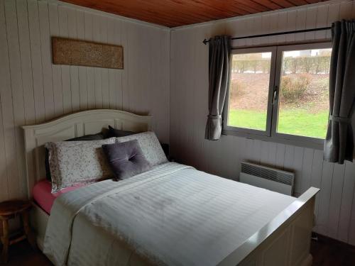 a bedroom with a white bed and a window at Bij Bart & Inge-La Boverie-Chalet nr 79 in Rendeux