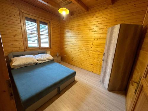 1 dormitorio con 1 cama en una habitación de madera en Virág Apartman, en Felsőtárkány