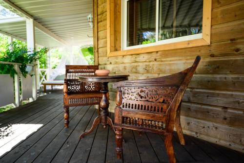 two chairs and a table on the porch of a house at Villa Vanille in Boisseron