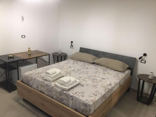 um quarto com uma cama com duas toalhas em LUX em Taviano