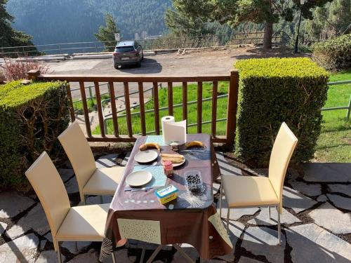 a table and chairs on a patio with a car at Apartamento cerca pista de esqui La Molina con piscina y Jardín in La Molina