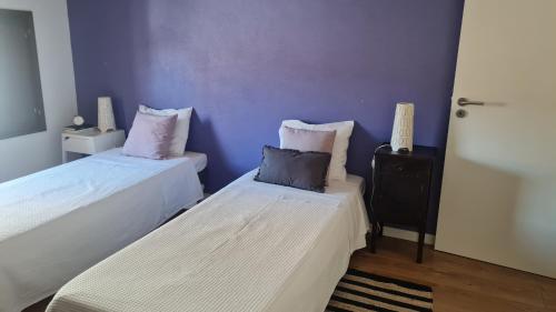 - 2 lits dans une chambre aux murs violets dans l'établissement Casa do Adro da Igreja Velha, à Janeiro de Cima