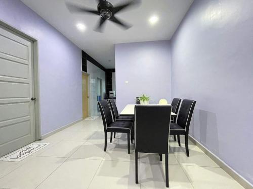 uma sala de jantar com uma ventoinha de tecto, uma mesa e cadeiras em JJ&KK Homestay em Taiping