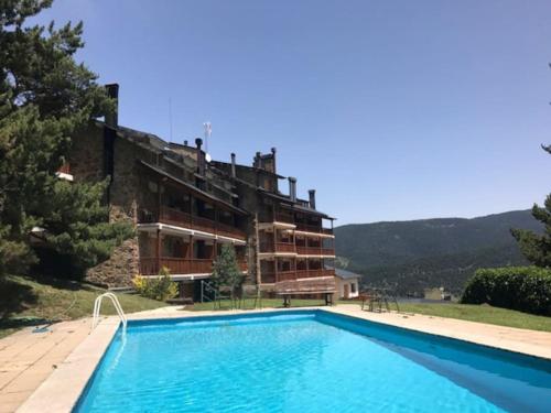莫利納的住宿－Apartamento cerca pista de esqui La Molina con piscina y Jardín，一座房子前面设有游泳池