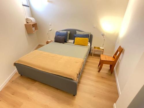 a small bedroom with a bed and a chair at Apartamento Mouzinho in Horta